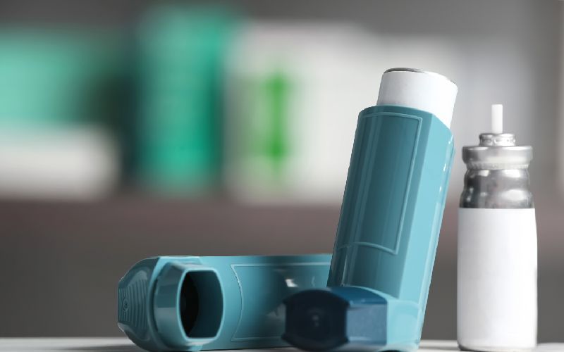 asthma inhalers on table against blurred